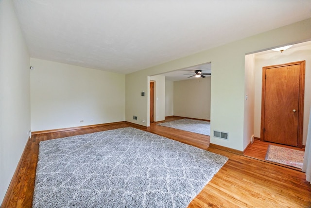 spare room featuring wood finished floors, baseboards, and a ceiling fan