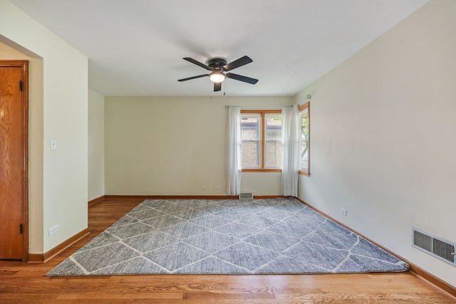 unfurnished room featuring baseboards, ceiling fan, and wood finished floors