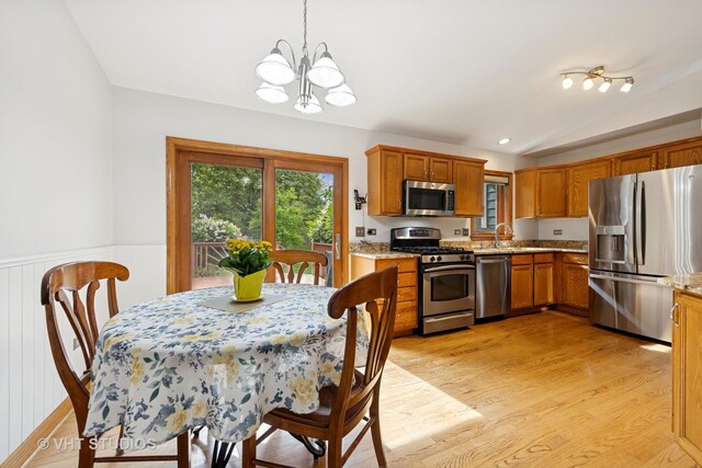 3 Starwood Ct, Bolingbrook, IL 60490 - kitchen featuring stainless steel appliances, a chandelier, light wood-style flooring, brown cabinets, and decorative light fixtures
