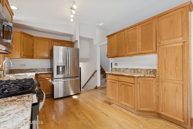3 Starwood Ct, Bolingbrook, IL 60490 - kitchen with appliances with stainless steel finishes, a sink, light wood-style floors, light stone countertops, and lofted ceiling
