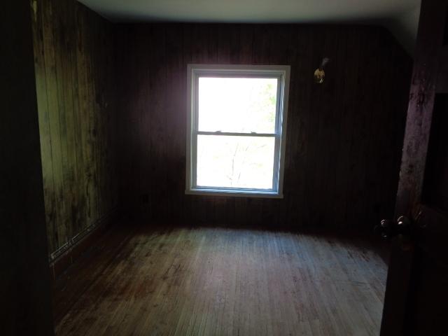 308 Genoa St, Cherry Valley, IL 61016 - empty room featuring wood finished floors and wooden walls