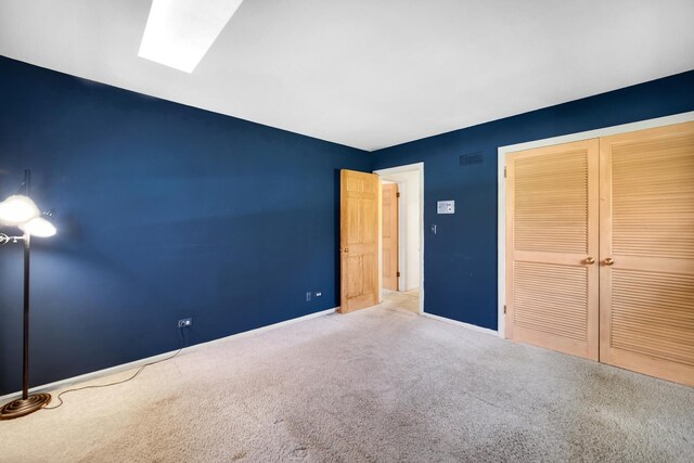 32381 N Forest Dr, Grayslake, IL 60030 - unfurnished bedroom featuring carpet flooring, a closet, a skylight, and baseboards