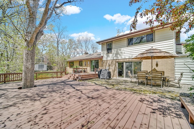 32381 N Forest Dr, Grayslake, IL 60030 - back of property featuring a wooden deck, a storage shed, brick siding, an outdoor structure, and outdoor dining space