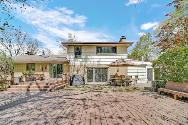 32381 N Forest Dr, Grayslake, IL 60030 - rear view of house with a chimney, brick siding, a deck, and outdoor dining space