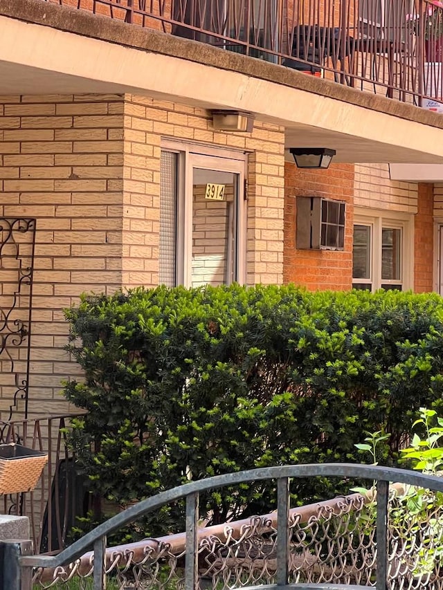 entrance to property featuring brick siding and a balcony