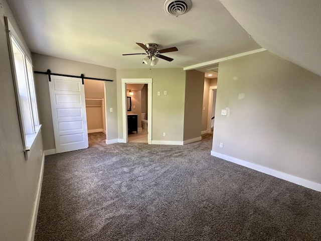 1527 7th St, Peru, IL 61354 - unfurnished bedroom featuring a barn door, ensuite bath, a closet, a spacious closet, and carpet