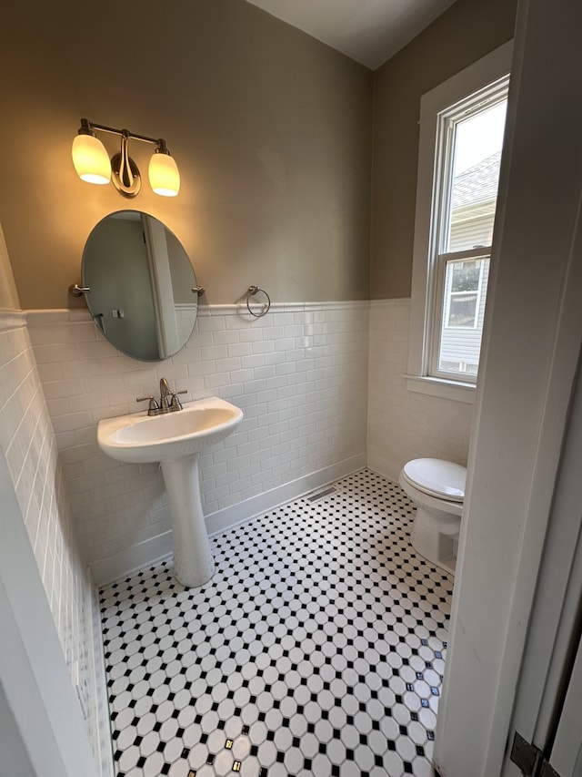 1527 7th St, Peru, IL 61354 - bathroom featuring wainscoting, tile walls, toilet, and tile patterned flooring
