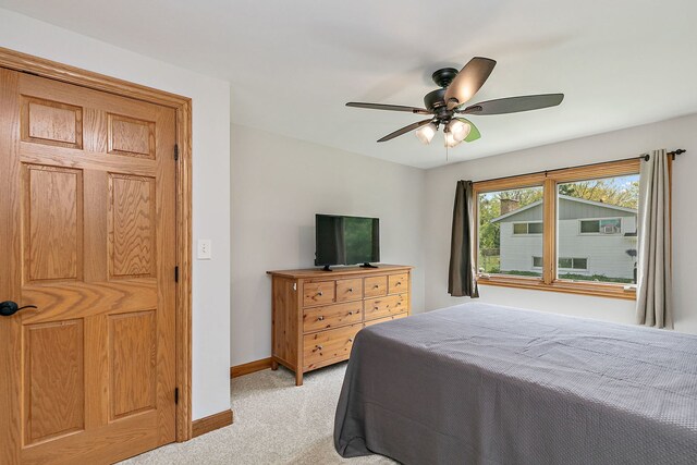 bedroom with light carpet, baseboards, and a ceiling fan