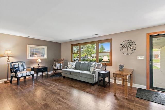 living room with dark wood finished floors, plenty of natural light, and baseboards