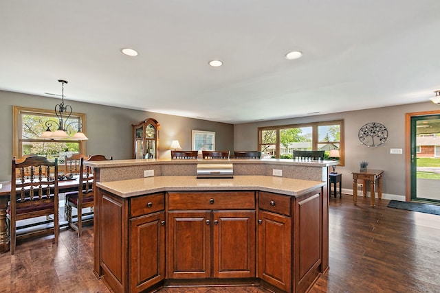 kitchen featuring dark wood-type flooring, decorative light fixtures, recessed lighting, and light stone counters