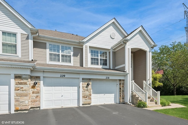 229 Concord Ln Unit 229, Carol Stream, IL 60188 - view of side of home with stone siding, driveway, a garage, and roof with shingles