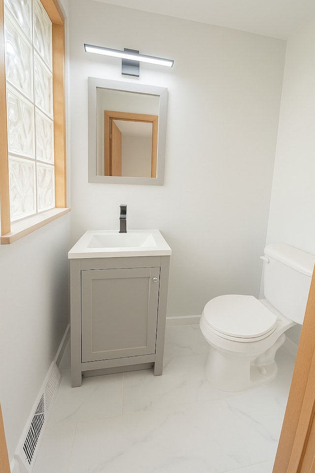 112 Burton Ave, Waukegan, IL 60085 - half bath with marble look tiles, toilet, vanity, and baseboards