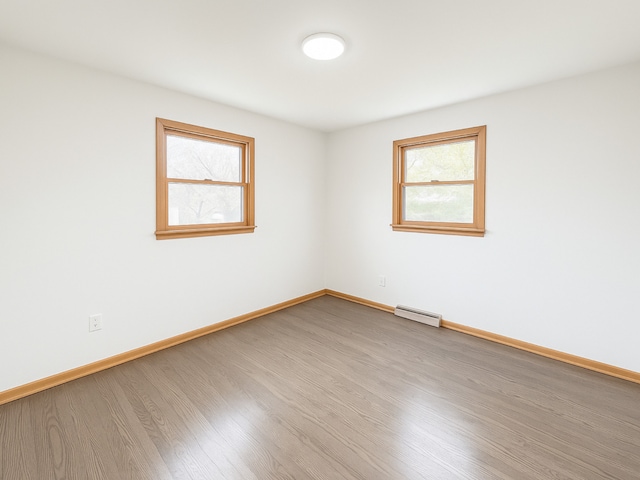 112 Burton Ave, Waukegan, IL 60085 - empty room with wood finished floors, baseboards, and baseboard heating