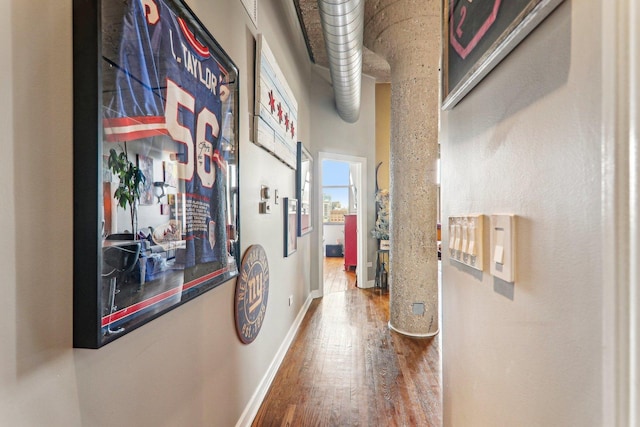 hallway featuring wood finished floors and baseboards