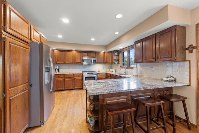 608 61st St, Lisle, IL 60532 - kitchen featuring appliances with stainless steel finishes, open shelves, a peninsula, light wood finished floors, and tasteful backsplash