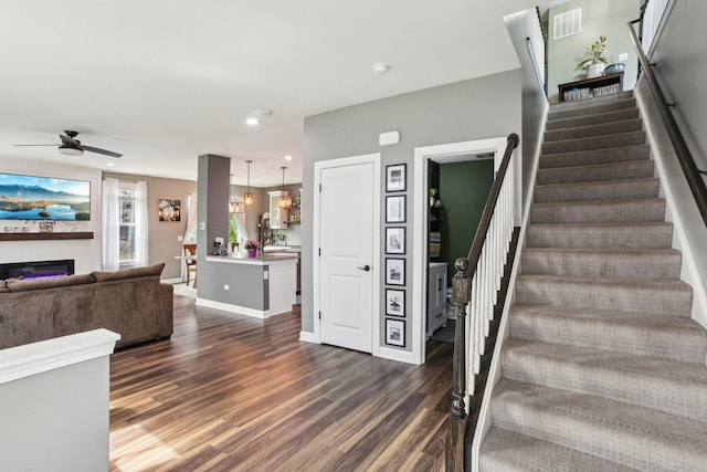 4144 Calder Ln, Aurora, IL 60504 - staircase featuring wood finished floors, a ceiling fan, a glass covered fireplace, recessed lighting, and baseboards