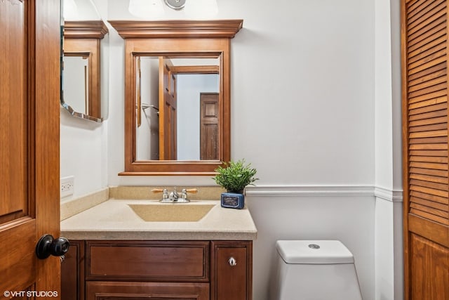 half bath featuring vanity and toilet
