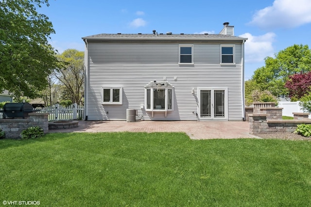 back of property with a patio area, a chimney, and central AC
