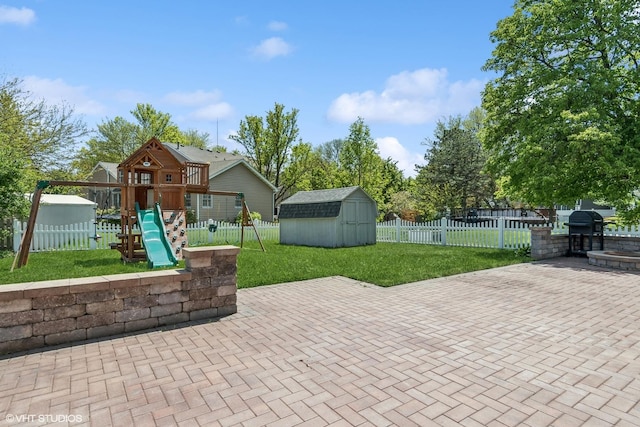 view of patio / terrace with a playground, a storage shed, and an outbuilding