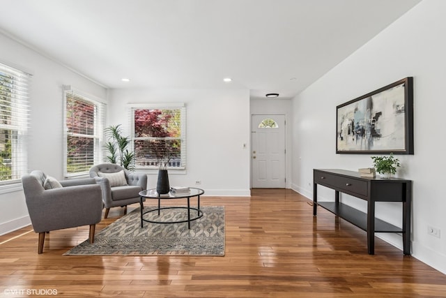 living area with healthy amount of natural light, wood finished floors, recessed lighting, and baseboards