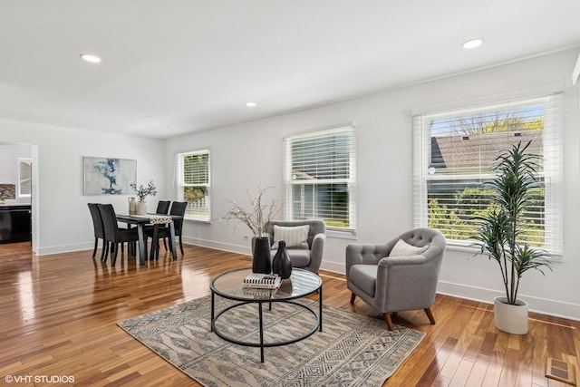 living room with wood finished floors, baseboards, and recessed lighting