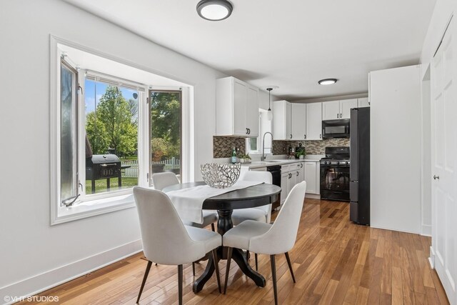 dining area featuring healthy amount of natural light, light wood-style flooring, and baseboards