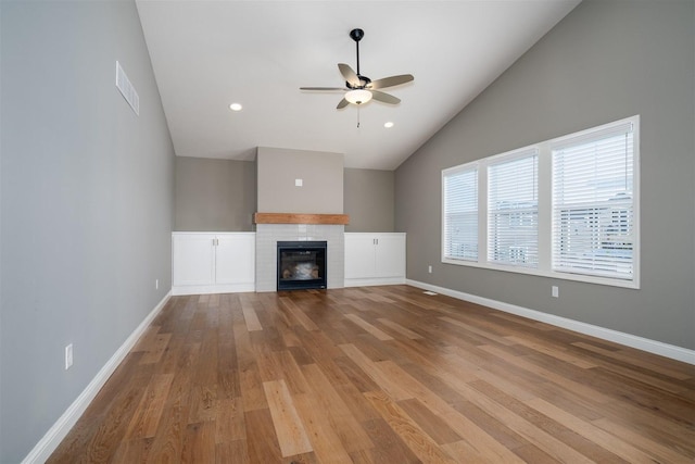 1172 Hershey Rd, Normal, IL 61761 - unfurnished living room featuring ceiling fan, a glass covered fireplace, wood finished floors, baseboards, and high vaulted ceiling