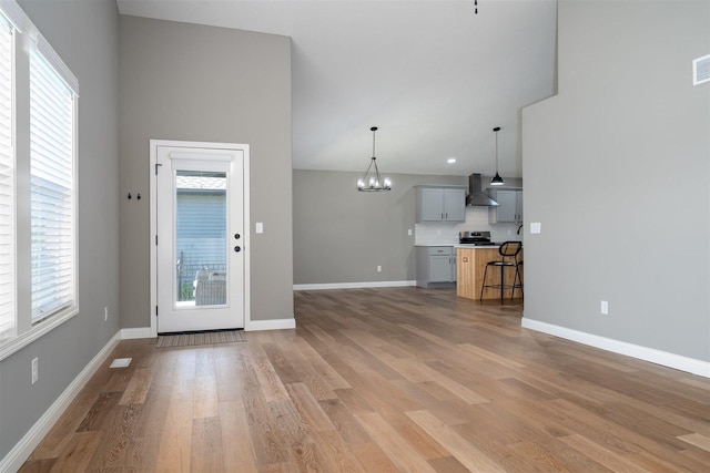 1172 Hershey Rd, Normal, IL 61761 - unfurnished living room featuring a chandelier, plenty of natural light, light wood-style floors, baseboards, and recessed lighting