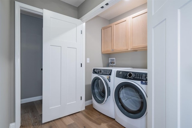 1172 Hershey Rd, Normal, IL 61761 - washroom featuring washing machine and dryer, light wood-type flooring, cabinet space, and baseboards