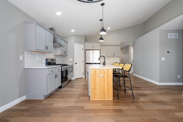 1172 Hershey Rd, Normal, IL 61761 - kitchen featuring stainless steel gas stove, a breakfast bar area, tasteful backsplash, baseboards, and lofted ceiling