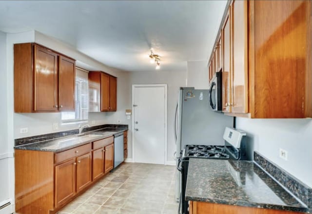 1711 W Estes Ave Unit 2N, Chicago, IL 60626 - kitchen with appliances with stainless steel finishes, brown cabinets, a sink, dark stone counters, and a baseboard radiator