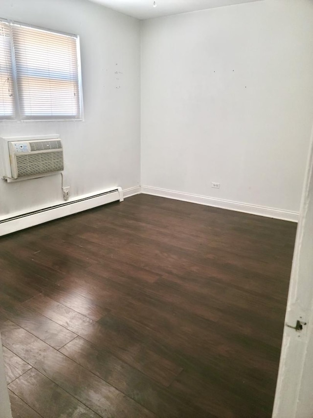 1711 W Estes Ave Unit 2N, Chicago, IL 60626 - spare room featuring dark wood-style flooring, a baseboard heating unit, an AC wall unit, and baseboards