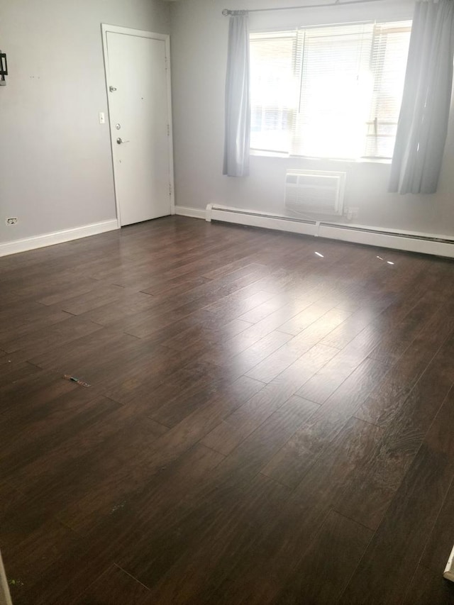 1711 W Estes Ave Unit 2N, Chicago, IL 60626 - empty room with a baseboard heating unit, dark wood-style flooring, and baseboards