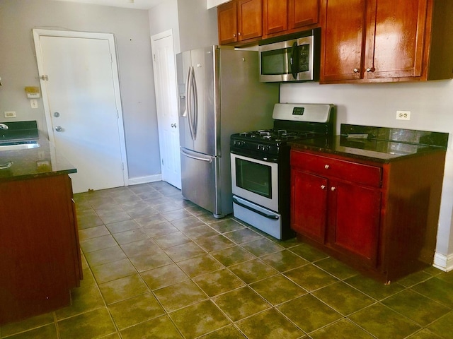 1711 W Estes Ave Unit 2N, Chicago, IL 60626 - kitchen featuring stainless steel appliances, a sink, dark tile patterned flooring, reddish brown cabinets, and dark stone countertops