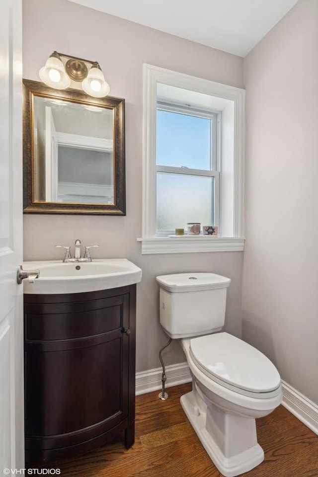 7337 N Mcvicker Ave, Chicago, IL 60646 - half bath with baseboards, wood finished floors, toilet, and vanity