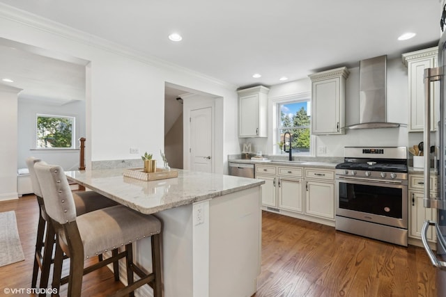 7337 N Mcvicker Ave, Chicago, IL 60646 - kitchen featuring stainless steel appliances, wall chimney range hood, a sink, a kitchen bar, and dark wood-style flooring