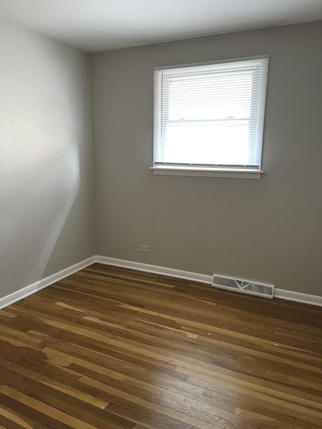 unfurnished room with dark wood-style floors and baseboards