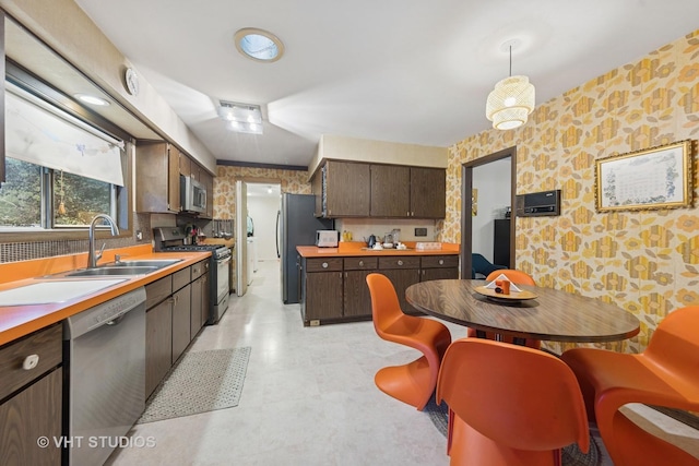 S070 River Ln, Winfield, IL 60190 - kitchen with appliances with stainless steel finishes, dark brown cabinets, a sink, light countertops, and wallpapered walls