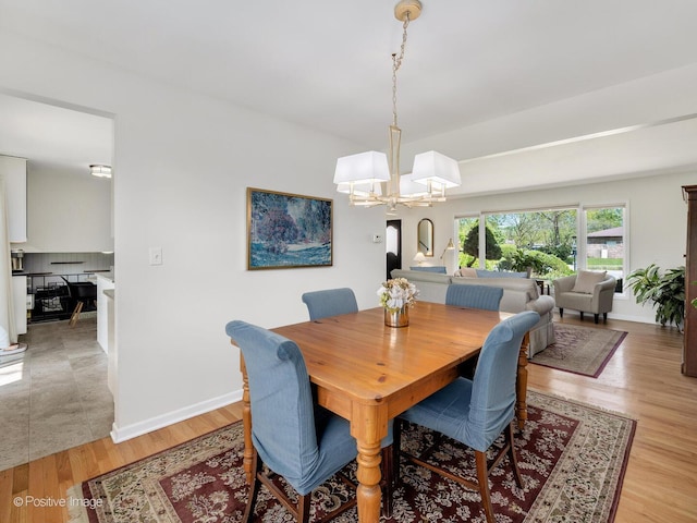 7102 Walden Ln, Darien, IL 60561 - dining room featuring a chandelier, light wood-type flooring, and baseboards