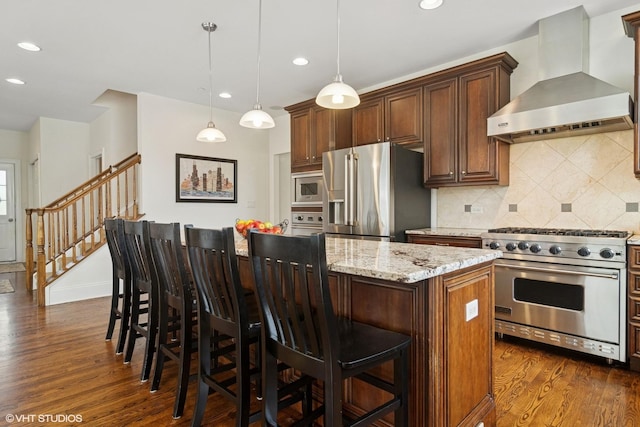 11 Crystal Downs Dr, Hawthorn Woods, IL 60047 - kitchen featuring wall chimney exhaust hood, appliances with stainless steel finishes, dark wood-style floors, a center island, and light stone counters