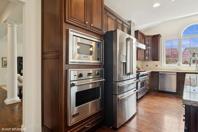 11 Crystal Downs Dr, Hawthorn Woods, IL 60047 - kitchen featuring appliances with stainless steel finishes, dark wood-type flooring, decorative backsplash, decorative columns, and lofted ceiling