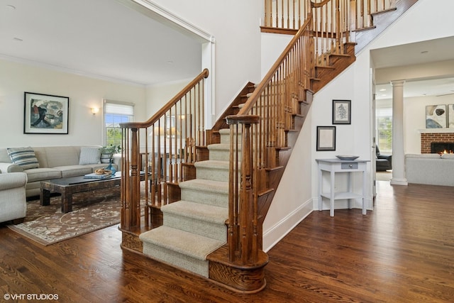 11 Crystal Downs Dr, Hawthorn Woods, IL 60047 - stairs featuring wood finished floors, crown molding, a brick fireplace, and ornate columns