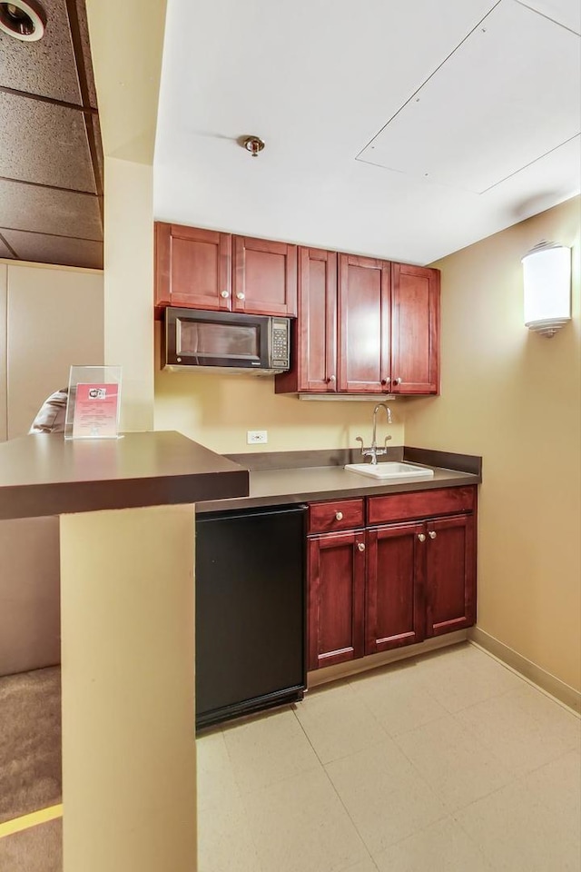 25 E Superior St Unit 2501, Chicago, IL 60611 - kitchen featuring stainless steel microwave, a sink, reddish brown cabinets, baseboards, and dark countertops