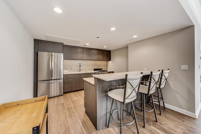 25 E Superior St Unit 2501, Chicago, IL 60611 - kitchen with freestanding refrigerator, light wood-style floors, light countertops, a breakfast bar area, and recessed lighting