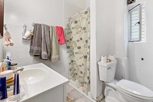 bathroom with toilet, tile walls, a shower stall, and vanity