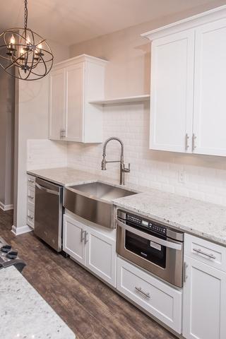 kitchen featuring a sink, stainless steel appliances, dark wood-type flooring, a chandelier, and backsplash