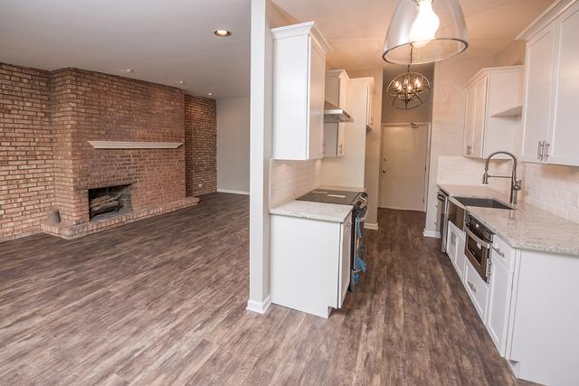 kitchen featuring appliances with stainless steel finishes, white cabinets, decorative backsplash, dark wood finished floors, and baseboards