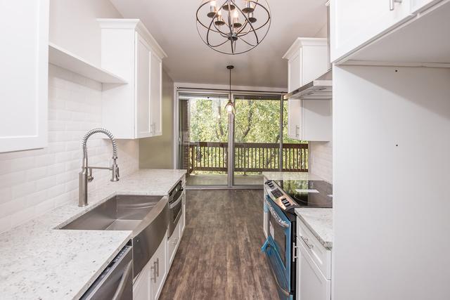 kitchen with appliances with stainless steel finishes, a chandelier, a sink, white cabinets, and backsplash