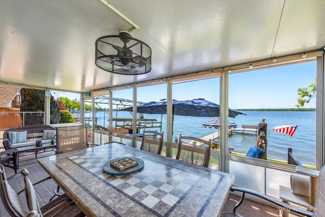 sunroom featuring a water view
