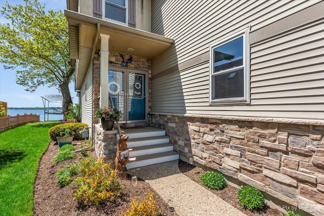 doorway to property featuring stone siding and a water view
